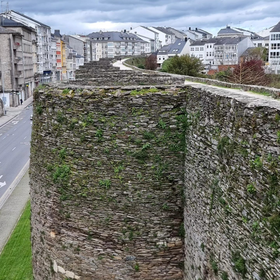 The Roman Walls of Lugo in northwestern Spain are a striking example of late Roman military engineering, wrapping around the historic city in a nearly complete circuit of over 2 kilometers. Built in the 3rd century to defend what was then the Roman settlement of Lucus Augusti, the walls stand up to 10 meters high and are remarkably intact, with over 70 towers still visible today. A wide walkway along the top allows visitors to circle the old town, offering views of both the ancient structure and the modern city beyond. Designated a UNESCO World Heritage Site, the walls are a rare surviving example of a fully intact Roman city fortification and remain an active part of Lugo’s urban fabric. 